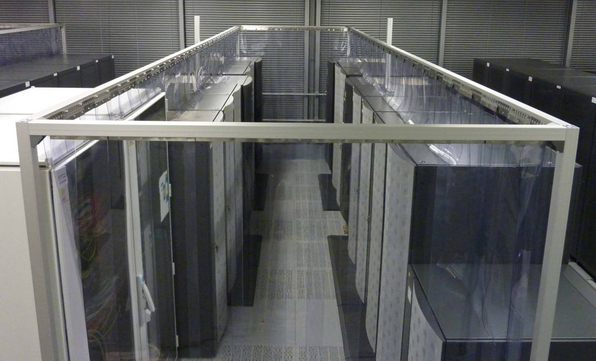 overhead view of data center hot aisle containment system with clear pvc strip curtains and metal frame enclosure