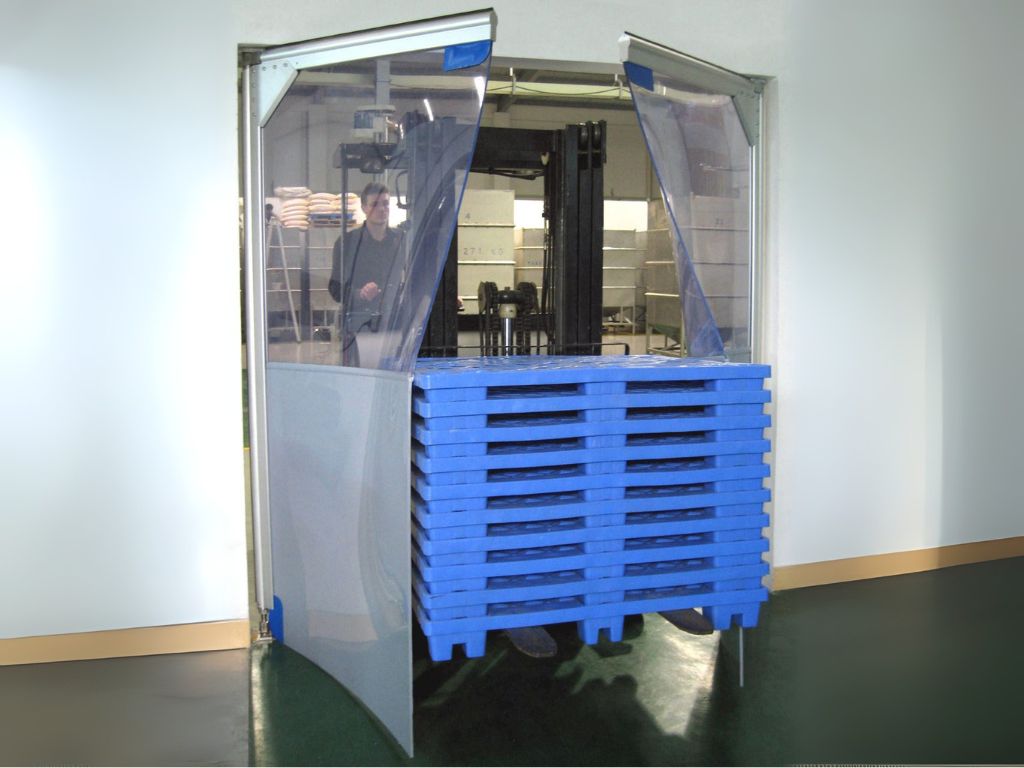 Forklift carrying blue pallets passing through transparent swing pvc doors.