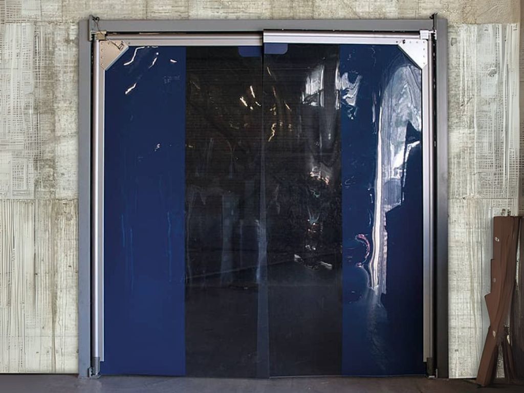 Industrial swing door with dark pvc panels and metal frame.
