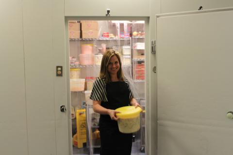 mulher segurando alimentos congelados saindo de uma câmara fria