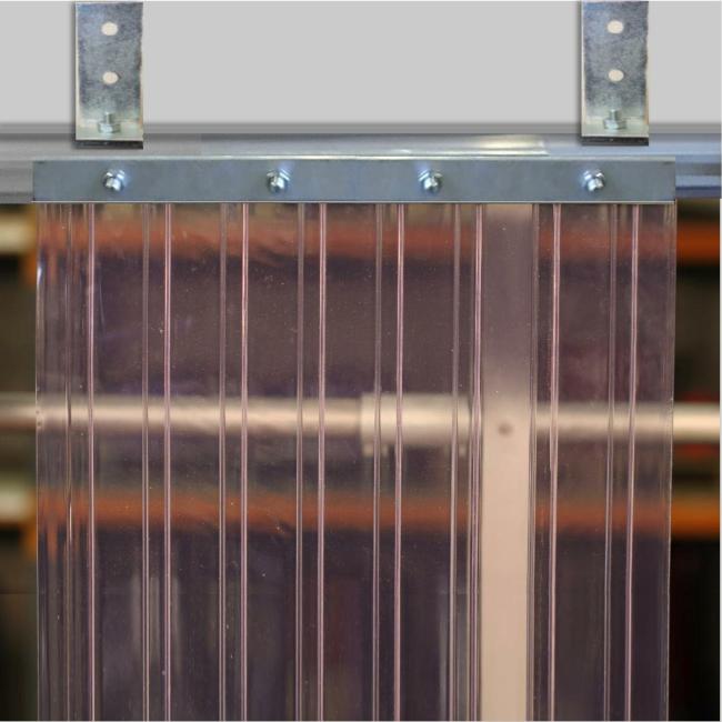 A clear PVC strip curtain mounted using twin-track hardware, with overlapping ribbed plastic strips hanging from a metal track for easy access and environmental control.